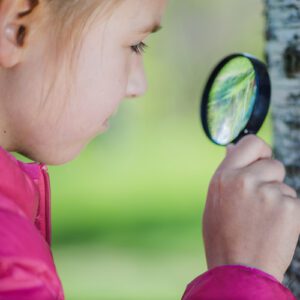 Mighty Minibeasts - GRH Training - girl with magnifying glass and tree